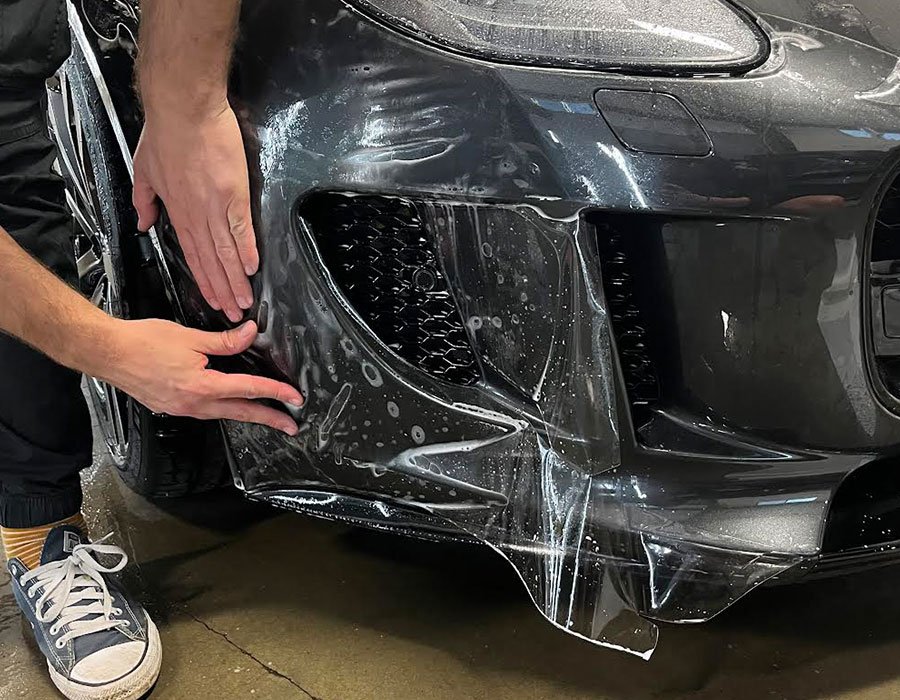 Paint protection film (PPF) being expertly applied to a car at Envy This Detailing in College Station TX showcasing precision and ultimate paint protection