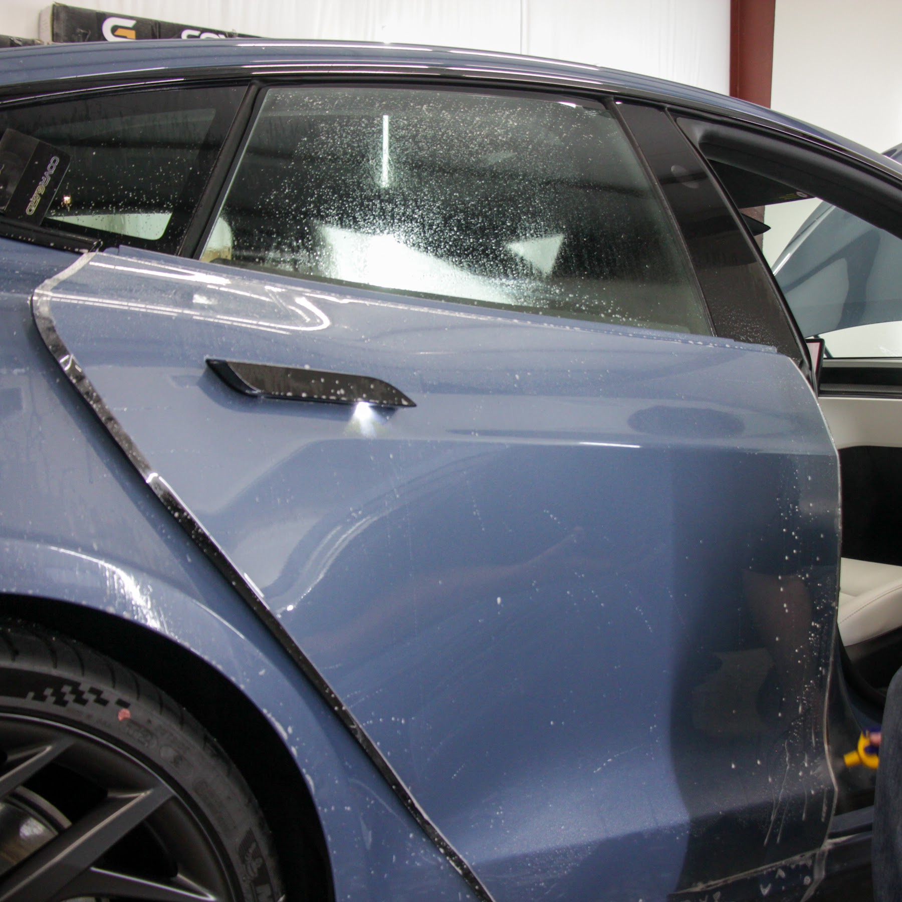 Color change paint protection film being installed on a Light Blue 2016-2020 Tesla Model S in College Station, TX Chevrolet C10 in the shop for vinyl and chrome delete work in Bryan College Station, TX