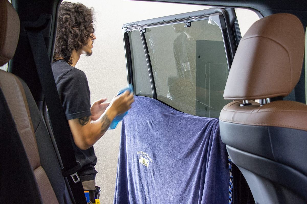 Envy This Detailing tint installer inside the vehicle applying window film in College Station