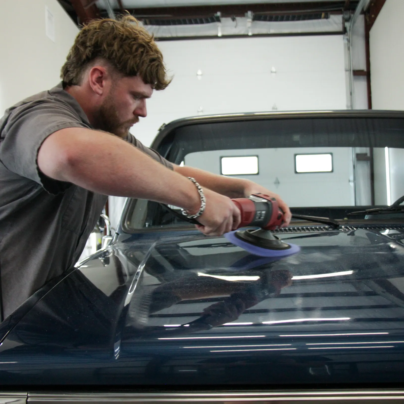 Machine polishing a hood during paint correction in College Station, TX